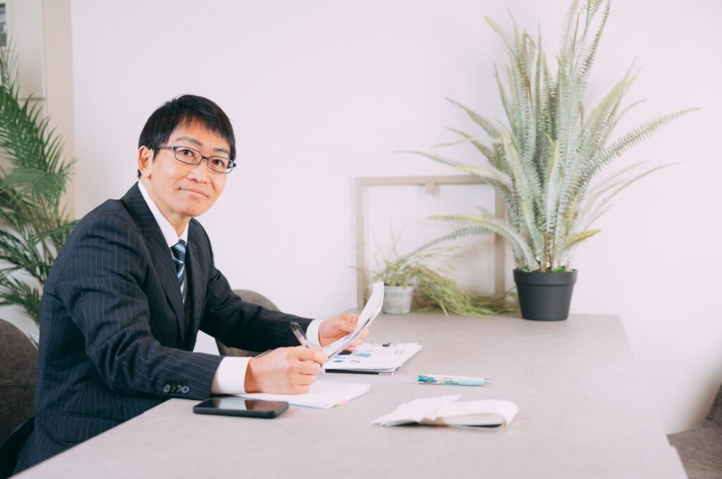 書類を持ったメガネの男性