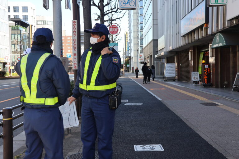 歩道に並んで立つ2人の警備員