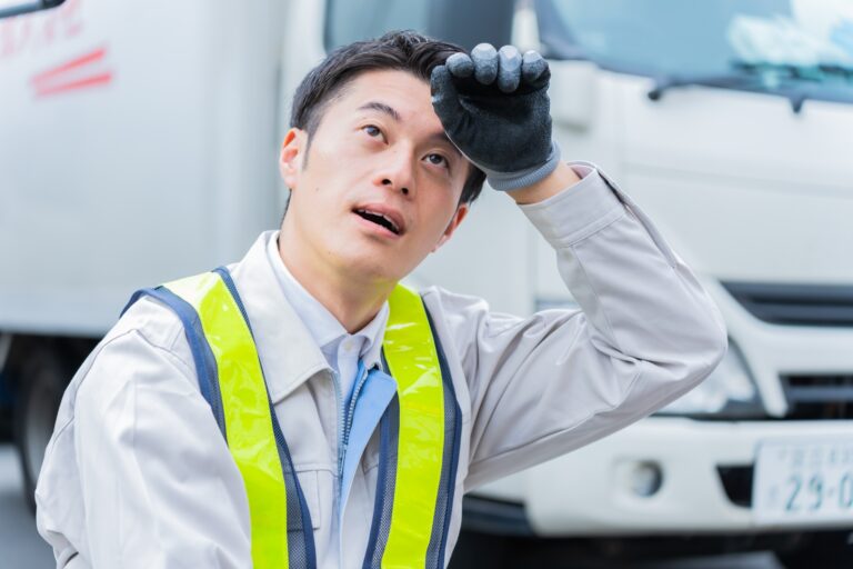 汗を拭う警備員の男性