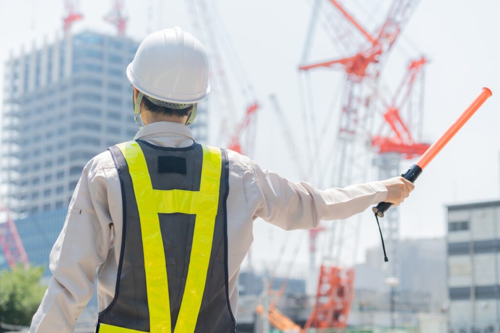 誘導棒を持つ警備員の後ろ姿