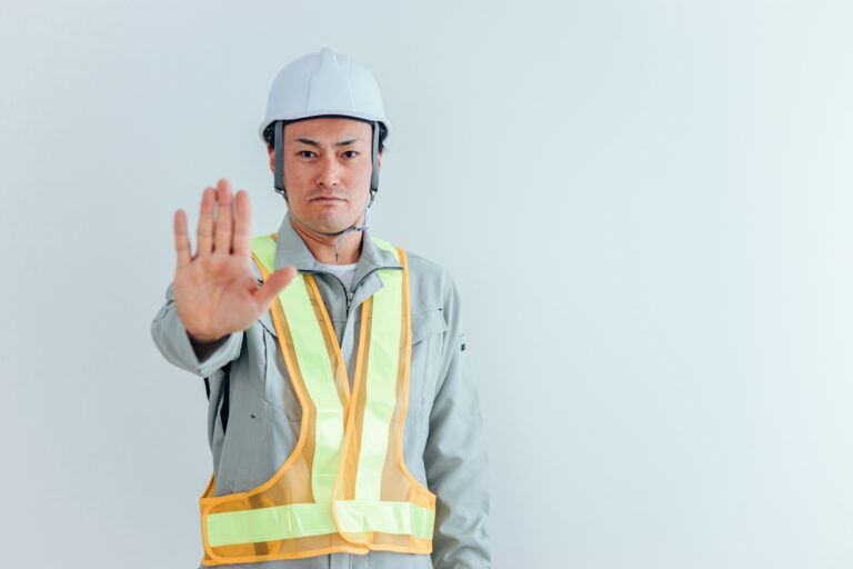 手のひらを見せる警備員