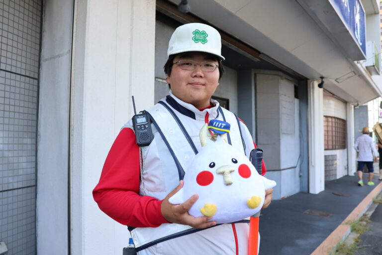 店舗の前で笑顔を見せる警備員