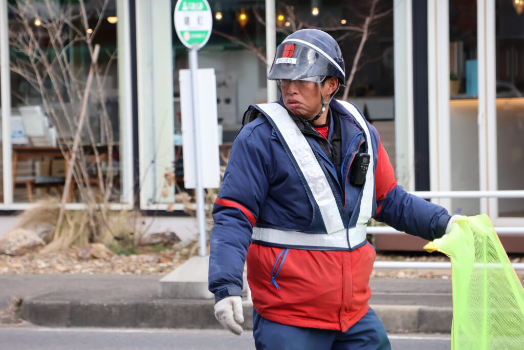 旗を持って交通誘導をする警備員