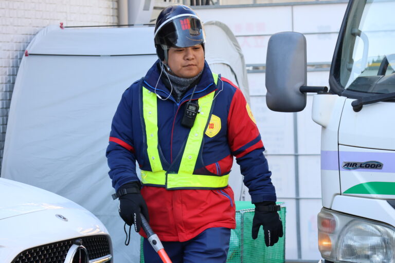 車両の横で誘導をする警備員